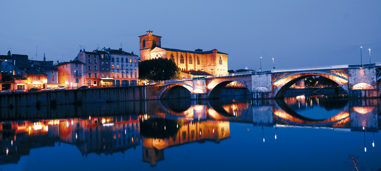 Les lumières de Romans et du pont se reflètent dans l’Isère à la tombée du jour